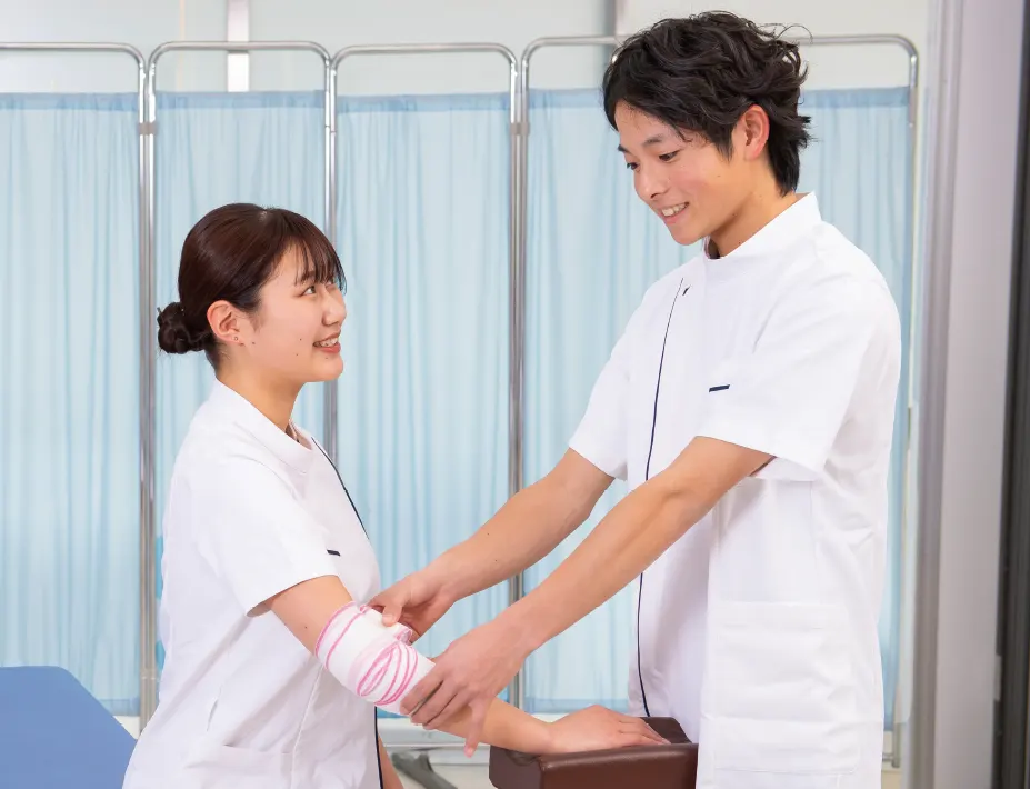 包帯固定を練習する学生2名の手元